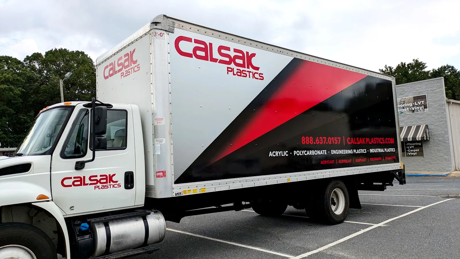 A box truck with a red, black, and white Calsak Plastics graphic covering the full box side and matching cab lettering.