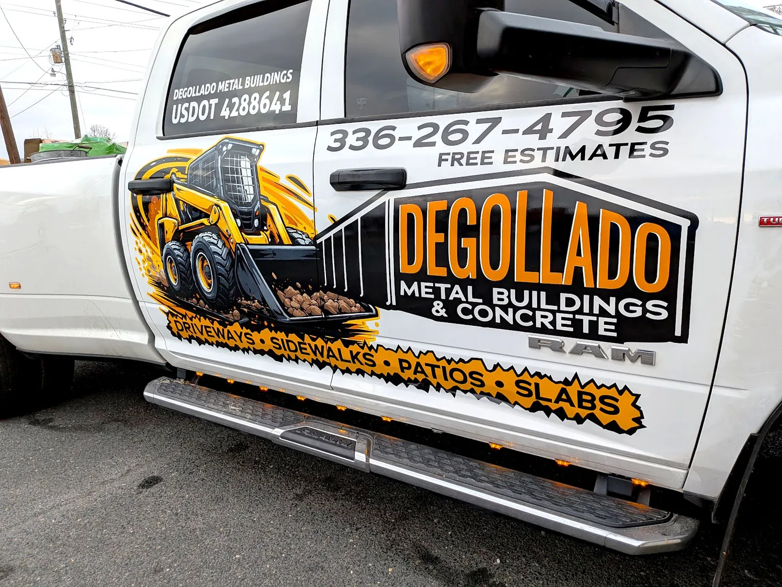 Side of a white Ram dually pickup with a large illustrated skid steer graphic and Degollado Metal Buildings and Concrete lettering.